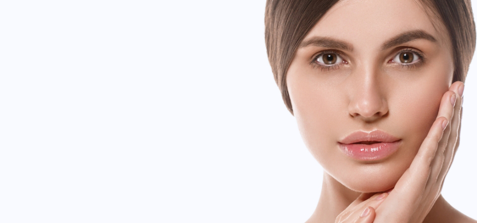 A serene woman gently touches her face, highlighting the results of PRP Therapy Insights.