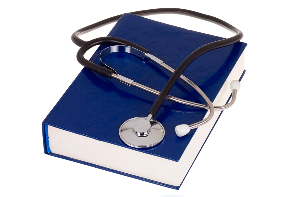 A stethoscope resting on a closed blue hardcover book. PRP Therapy Solutions