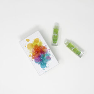 Overhead view of two ZK FACE serum bottles alongside a color-splattered canvas on a white background.