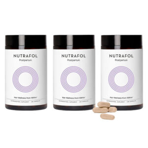 Three bottles of Nutrafol Postpartum hair wellness supplement with capsules displayed in front.