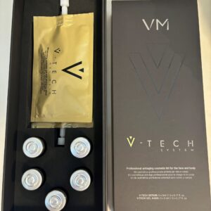 An open box of V-TECH SYSTEM showcasing a set of vials and a gold-colored gel mask packet, arranged neatly for professional use.